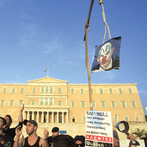 O fotografie a premierului Greciei, George Papandreou, în postura de clown spânzurat a fost agăţată, la finalul săptămânii trecute, în faţa Parlamentului de către protestatari. Aceştia au strigat: Nu sunt patrioţi aici. Legaţi-i!
