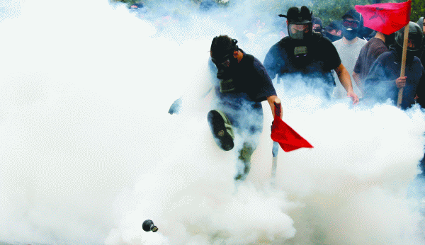 Demonstrator kicks away tear gas canister outside the Parliament in central Athens, during a rally against plans for new austerity measures, Wednesday, June 15, 2011. A 24-hour strike by Greece"s largest labor unions is set to cripple public services Wednesday, as the Socialist government begins a legislative battle to push through last-ditch cost cutting reforms that will exceed its own term in office. Demonstrators had camped outside the parliament since May 25, 2011. 